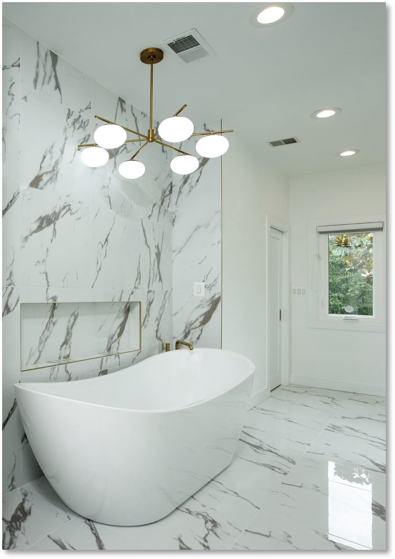 Experience award-winning design in this luxurious Potomac bathroom, featuring white and gray marble walls and floors, a sleek freestanding bathtub, modern gold-accented fittings, a glass-enclosed shower, and a contemporary chandelier.