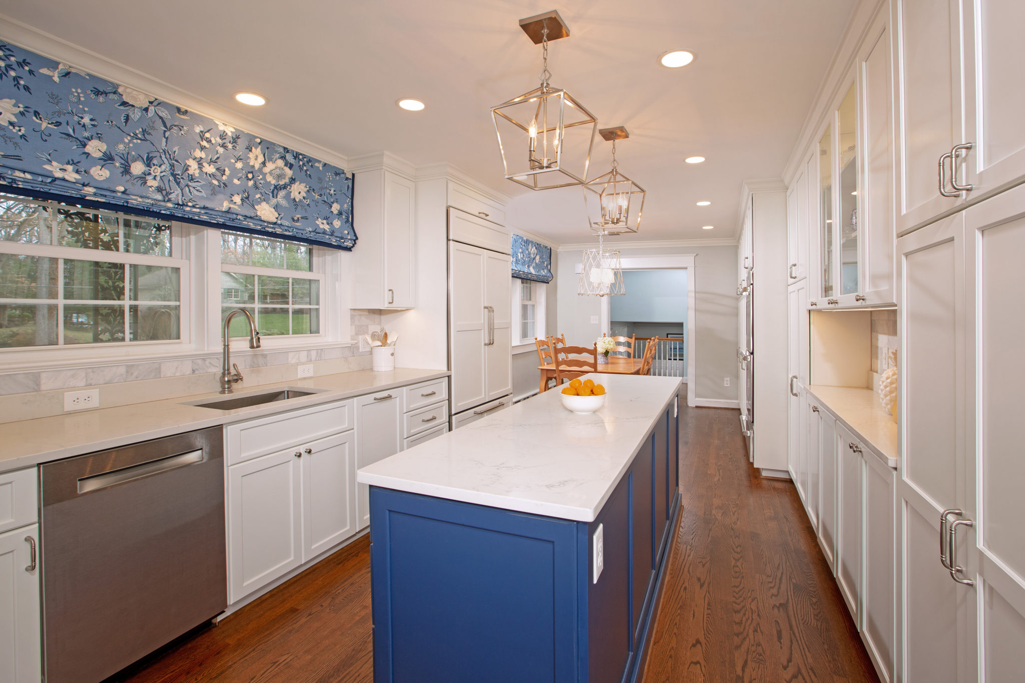 A modern kitchen featuring white cabinets, a countertop, a sink with a tap, and various home appliances. The room has a floor and ceiling typical of indoor spaces, with cabinetry and drawers for storage.Faraday_kit_Eatin_1-10-20_597