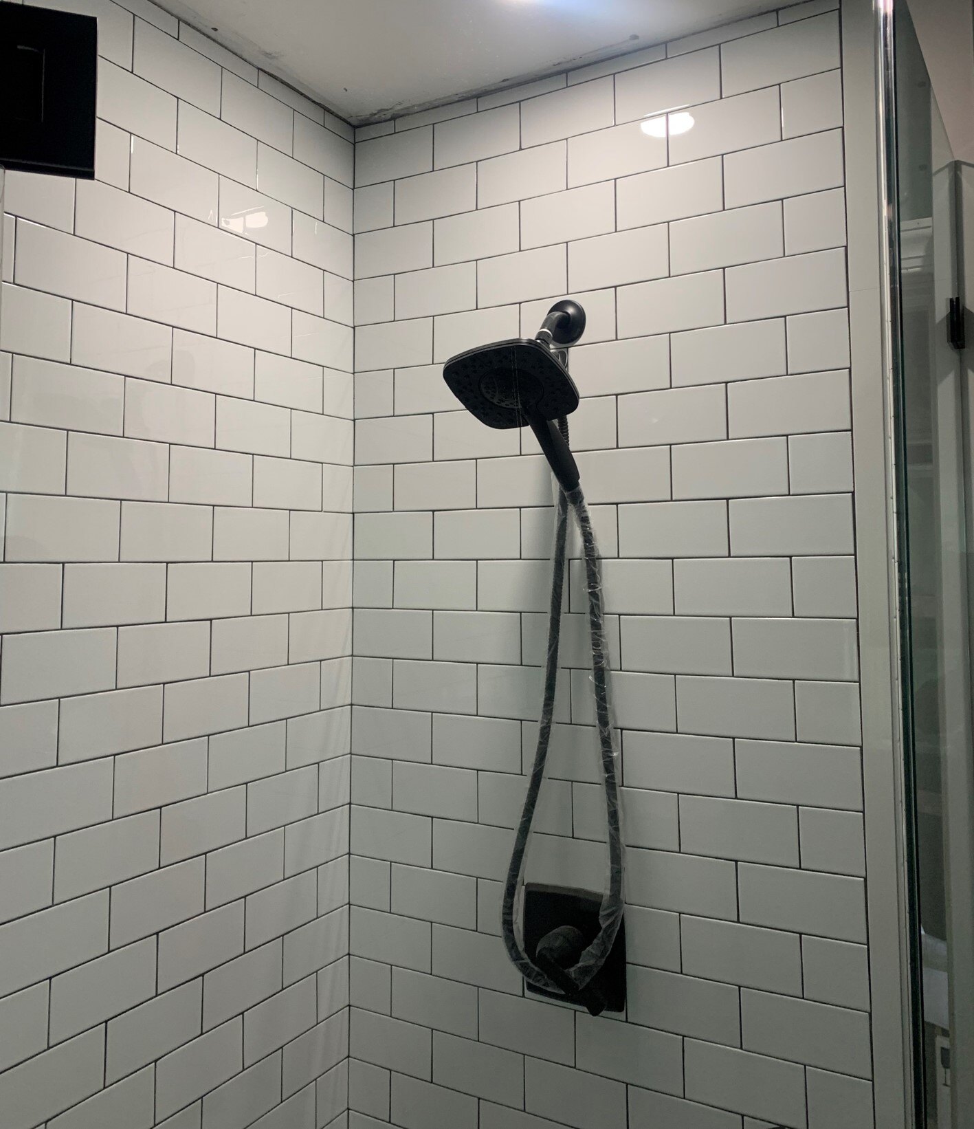 white tile shower with black showerhead