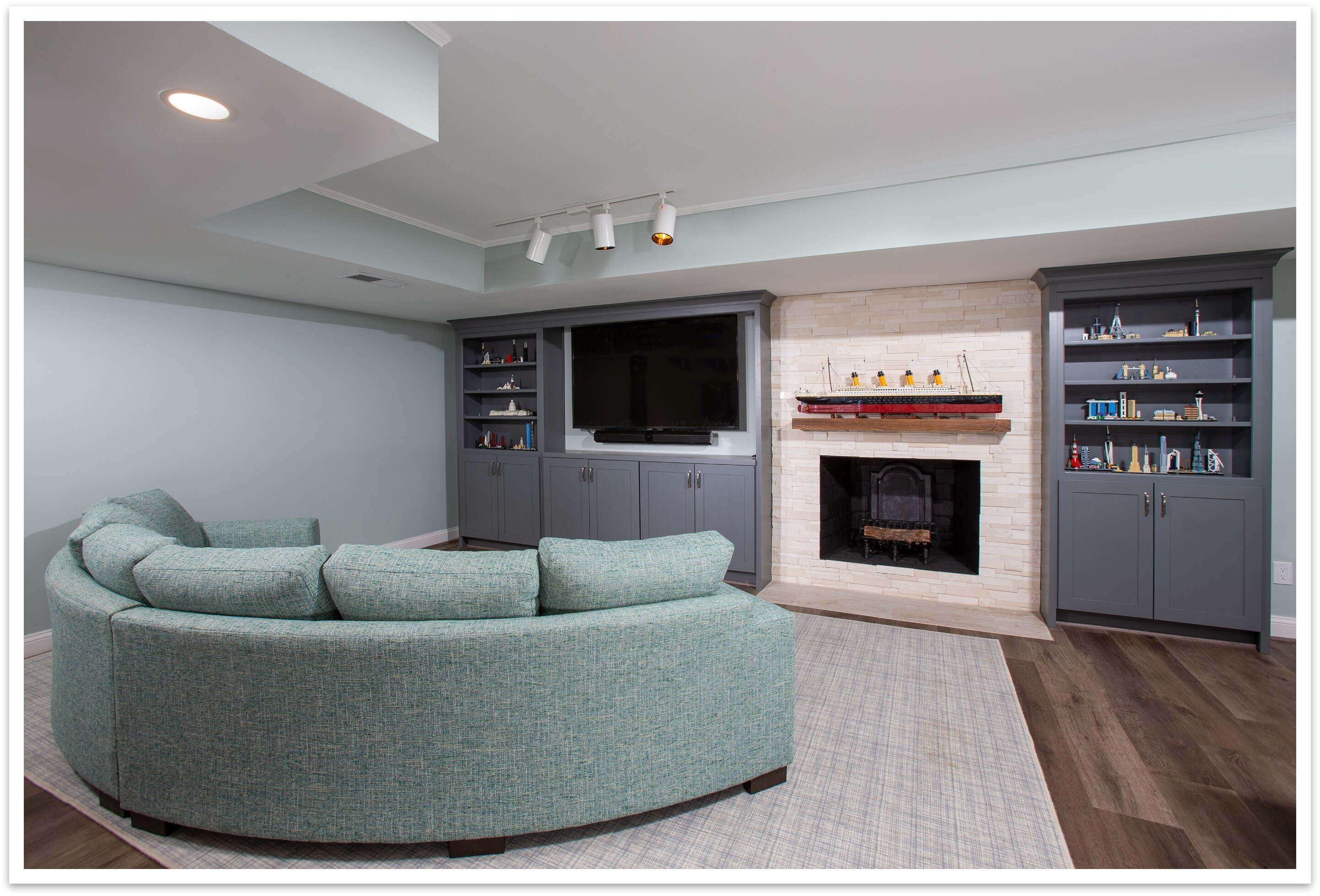 A modern open-concept living space in Chevy Chase features a fireplace and built in bookcases.